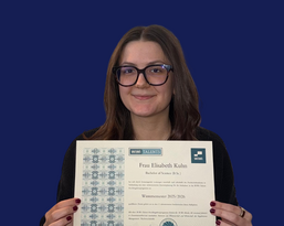 Ms. Elisabeth Kuhn is holding a certificate that confirms her Bachelor of Science degree from the winter semester of 2015/2016.